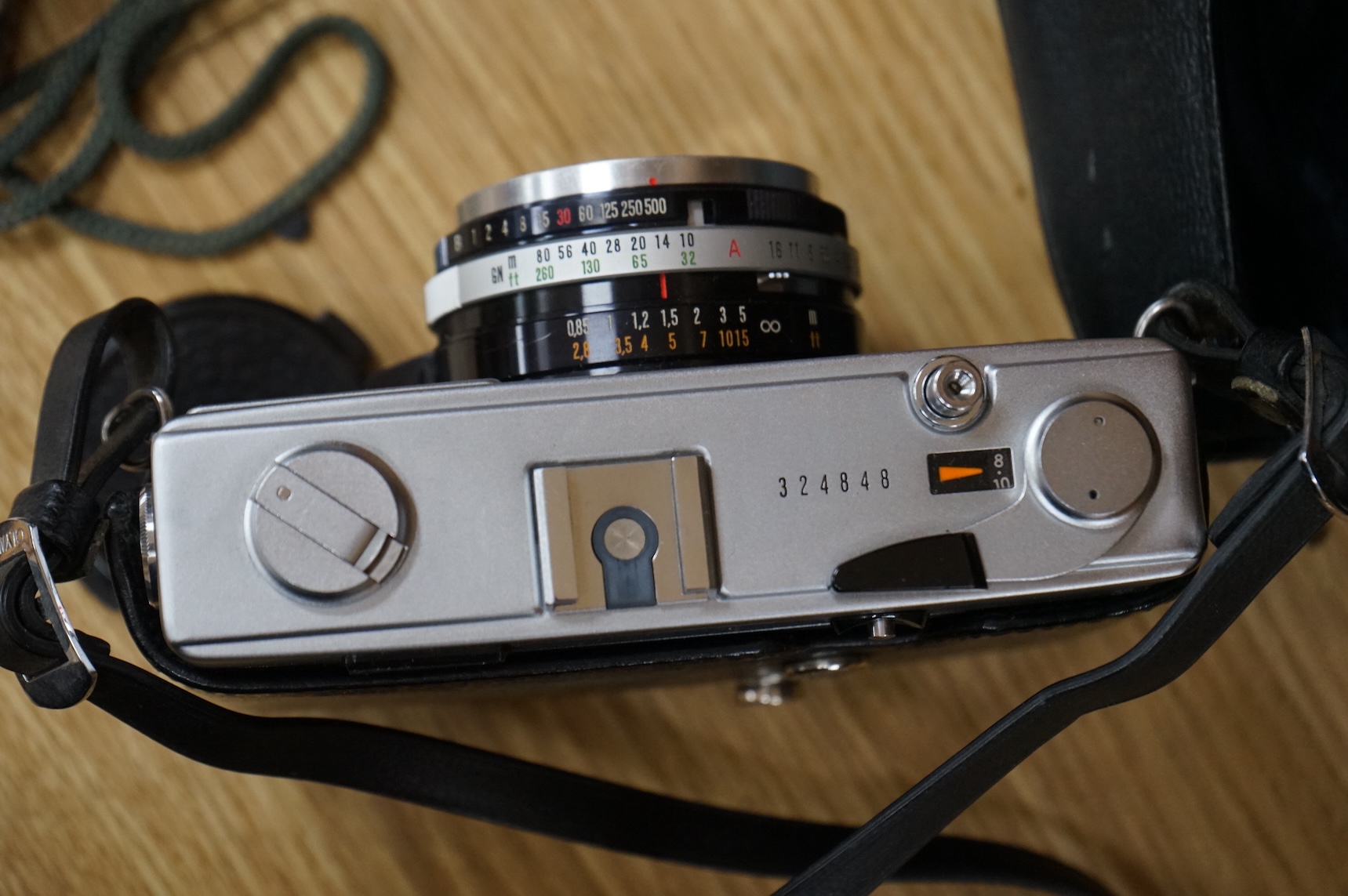 A cased Olympus 35SP camera, together with two more recent digital cameras